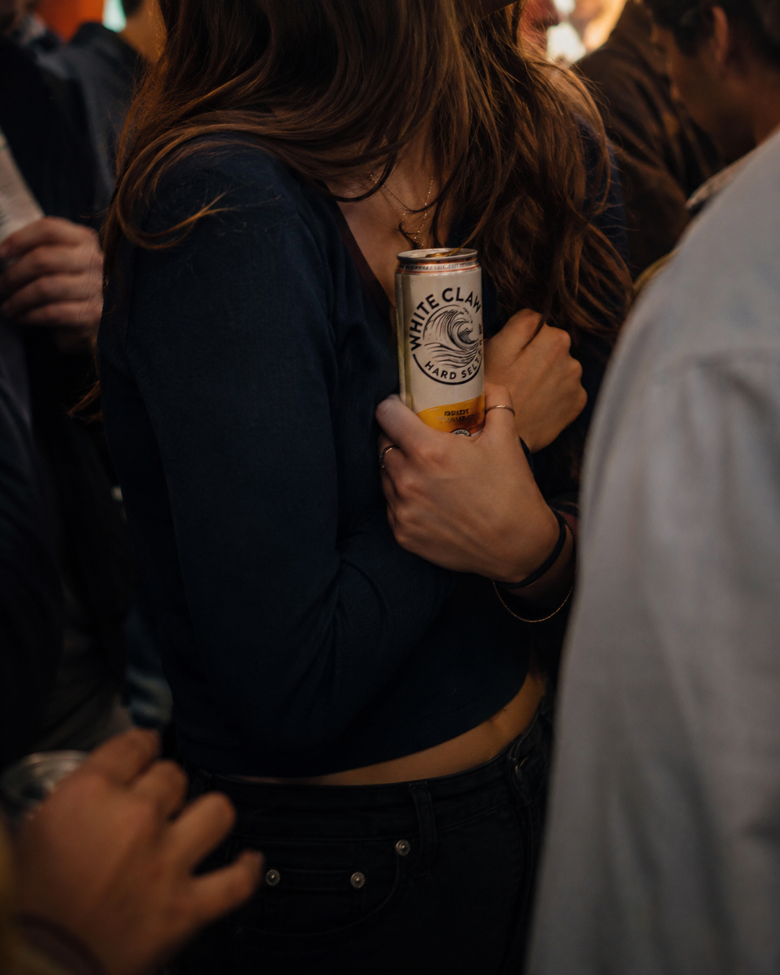 Person holding a can in a social setting